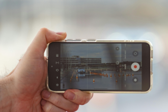 Ilustrasi seseorang merekam video secara diam-diam menggunakan smartphone dari belakang korban.