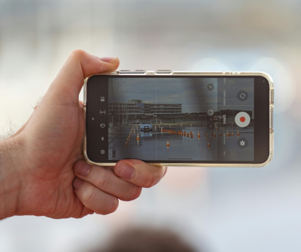 Ilustrasi seseorang merekam video secara diam-diam menggunakan smartphone dari belakang korban.